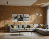 Salon moderne avec murs et plafond recouverts de **pièces en OSB**. Un canapé gris confortable, une table basse en bois et des tableaux noirs et blancs complètent l'espace.