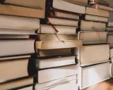 Pile di libri, alcuni con segnalibri rossi, pronti per essere letti. Ecco i miei ultimi libri consigliati.