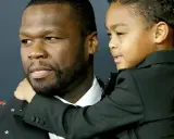 50 Cent z synem, chłopiec w czarnym garniturze przytula się do ojca.