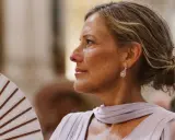 Elegantes peinados para madrinas de 60 años: un recogido bajo y pulido, con pendientes de brillantes, ideal para un evento especial.