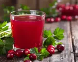 Szklanka soku żurawinowego z żurawiną i korzeniem łopianu. Naturalny sposób, jak wypłukać bakterie z moczu.