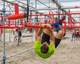 Mann hangelt sich kopfüber durch einen Hindernisparcours. Ein echter **obstacle run**!