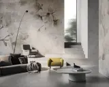 Soggiorno moderno con divano grigio, poltrone e tavolino. Le pareti sono decorate con **case con carta da parati** a tema floreale, creando un'atmosfera elegante.