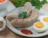 Biała kiełbasa z jajkiem i ketchupem, obok czosnek i natka. Idealne dodatki, jakie przyprawy do białej kiełbasy?