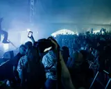 Publik jublar på en konsert i Göteborg. En artist uppträder på scenen i blått ljus och rök. Många i publiken filmar med sina mobiler.
