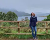 Frau vor schottischer Burg bei typischem Septemberwetter. Die Landschaft ist grün, das Wetter schottland september ist wechselhaft, aber die Stimmung ist gut.
