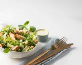 Salade César fraîche avec poulet grillé, croûtons et copeaux de parmesan, accompagnée de sa sauce crémeuse.
