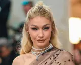 Gigi Hadid luce un maquillaje con perlas, con pequeños adornos brillantes en los ojos y un collar de perlas.