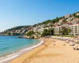 Piękna plaża z turkusową wodą i białymi hotelami na wzgórzu. Idealne miejsce, gdzie na egzotyczne wakacje.