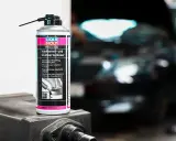 Puszka preparatu do czyszczenia wtryskiwaczy Liqui Moly na tle rozmazanego silnika.