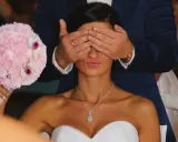 Pan młody zasłania oczy pannie młodej, która trzyma bukiet. To tradycja oczepin, co to za zwyczaj?