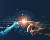 Eine Roboterhand und eine menschliche Hand berühren sich, ein Symbol für die utopie definition von KI und Menschheit.