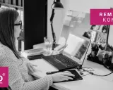 Kobieta pracuje przy biurku, na którym znajduje się laptop, monitor i dokumenty. Na ekranie monitora widnieje napis "REMANENT KOŃCOWY".