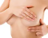 Mani che esplorano il seno, lasciando un leggero segno del reggiseno sulla pelle.