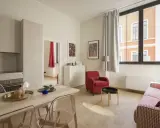 Modernes Wohnzimmer mit Essbereich. Klare Linien und helle Farben prägen die verschiedenen style richtungen. Rote Akzente setzen Akzente.