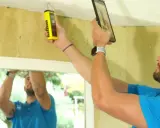 Un homme utilise un appareil pour détecter une fuite d'eau au plafond.