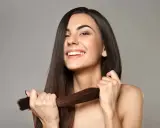 Mujer sonriente muestra su cabello largo y sedoso, un ejemplo de cómo cuidar el pelo para que luzca saludable y brillante.