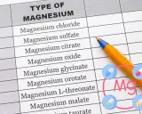 Tabela z rodzajami magnezu, w tym glicynian magnezu. Obok długopis i ikony tabletek.