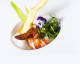 Homard poêlé, écume légère, chips de légume et fleur, une spécialité jurassienne raffinée.