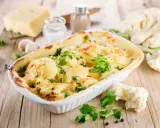 Un délicieux gratin de chou-fleur doré et gratiné, garni de persil frais, prêt à être dégusté.