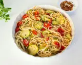 Pyszny makaron z cukinii, pomidorkami i parmezanem, gotowy do podania.