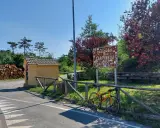 Bicicletta gialla appoggiata alla staccionata al Passo dei Carpinelli, con un cartello che indica l'altitudine e un piccolo edificio.