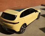 Le Leapmotor B05, un SUV jaune vif, se gare près d'un mur de briques.
