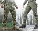 Dwóch mężczyzn w spodniach ripstop, jeden w kamuflażu, drugi w zielonych, na tle zimowego lasu.