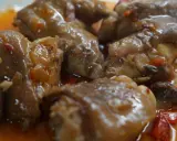 Manitas de cerdo en salsa, un plato de comida típica de Valladolid, con trozos de pimiento y cebolla.