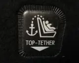 Symbol mocowania fotelika ISOFIX z kotwicą i dzieckiem. To jest oznaczenie TOP TETHER.
