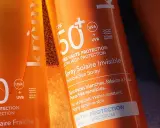 Trois tubes de crème solaire, tous avec SPF 50, prêts pour la protection solaire. L'un est un spray invisible, l'autre un lait hydratant.
