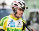 Radsportler mit Helm und Mikrofon, bereit für ein Interview nach einem harten Rennen, vielleicht dem Race Across America.