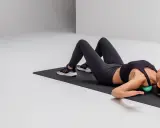 Frau rollt mit einem Ball über ihre Schulter Faszien.