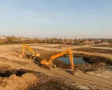 Excavadoras trabajan en un sitio de remediación de suelos, moviendo tierra y agua para restaurar el terreno.