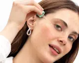 Donna applica un siero per la zona contorno occhi con un contagocce.