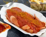 Currywurst mit Pommes und einer köstlichen Currysoße, die Lust auf das Currysoße Rezept macht.