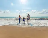 Familia disfrutando de un día en la playa de Altea con niños, jugando entre las olas.