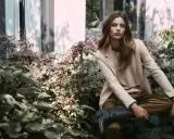 Donna elegante con blazer beige e stivali texani, un'ispirazione su come vestirsi a 45 anni con stile e audacia.