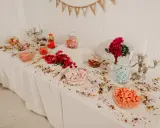 Elegante candy bar boda con dulces de colores, flores rojas y candelabros plateados.