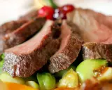 Saftiges Wildfleisch, zart geschnitten, mit knackigem Gemüse und Beeren garniert. Eine köstliche Antwort auf die Frage: Ist Wildfleisch gesund?