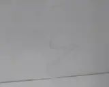 Na jasnych płytkach widać kilka dziwnych plam, jedna z nich przypomina kształtem literę "S".