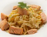 Deliciosa pasta con trozos de salmón rosado, cubierta con una cremosa salsa y espolvoreada con perejil fresco.