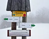 Szlak w Magurskim Parku Narodowym. Znak wskazuje Wysokie (657 m n.p.m.), najwyższy szczyt, oraz kierunki do Krempnej i Ożennej.