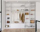 Idéal pour aménager un placard : étagères blanches remplies de vêtements, accessoires et boîtes.