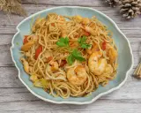 Delicioso plato de noodles con gambas, pimientos rojos y perejil fresco. Un festín para los sentidos.