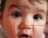 Primo piano di un bimbo con griglia della regola dei terzi. Gli occhi sono posizionati sui punti di intersezione, creando ritratti efficaci.
