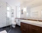 Baños modernos y reformados con plato de ducha, lavabo doble y mueble de madera.