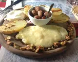 Piatto con formaggio fuso, patate arrosto, noci e cipolline. Un assaggio dei piatti tipici Valle d'Aosta.