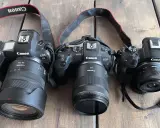 Trzy aparaty Canon EOS R z różnymi obiektywami, w tym jeden z trybem obrazu APS.