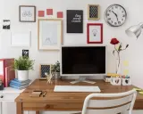 Bureau organisé pour une **optimisation** du travail : écran, clavier, plante verte, et décorations murales inspirantes.